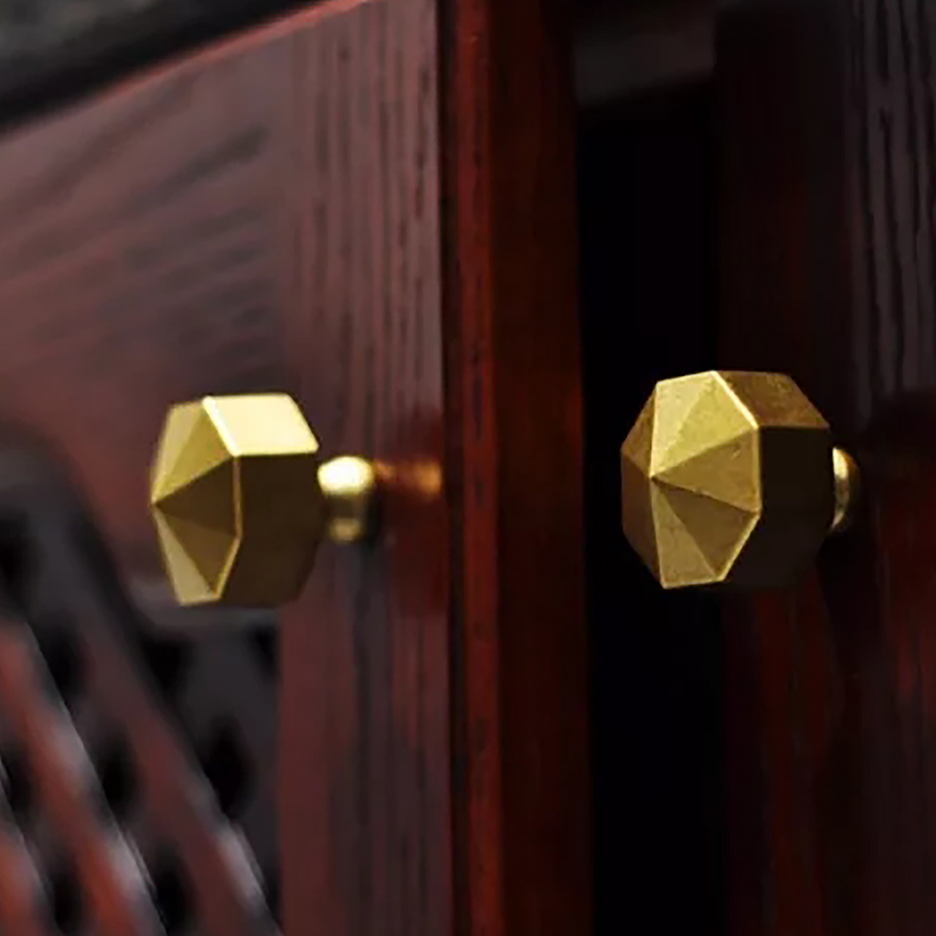 This image showcases a stunning gold brass knob affixed to a brown wood drawer. The combination of the rich gold brass and the warm brown wood creates an exquisite aesthetic. The knob can serve as a luxurious addition to various furniture pieces, including cabinets, drawers, kitchen fixtures, bathroom accessories, bedroom furniture, wardrobe doors, and main doors. Its versatility makes it an ideal choice for enhancing the elegance and functionality of any space.